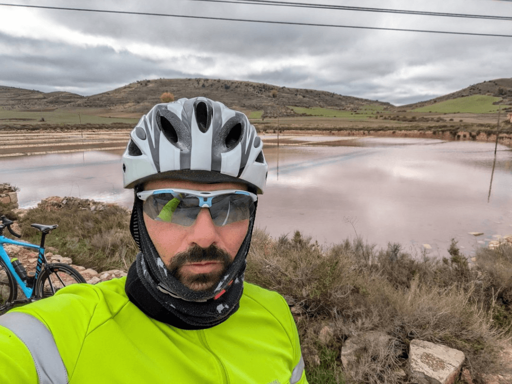 Arturo cycling beside a reservoir