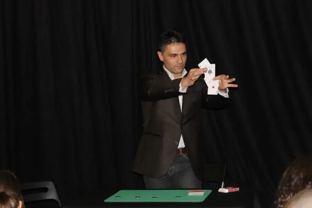 Arturo performing a card illusion on stage
